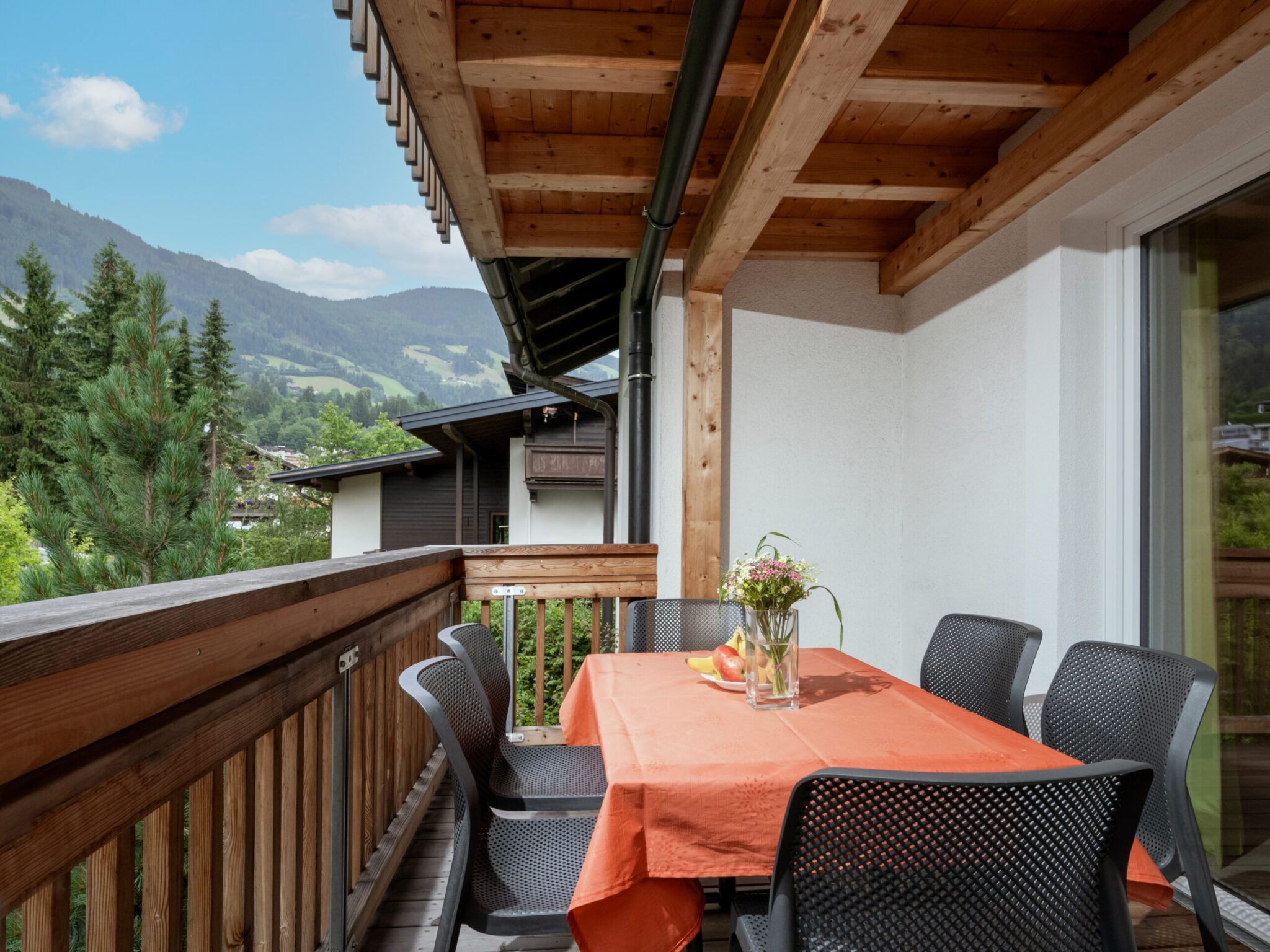 Ein Balkon mit gedecktem Tisch und Ausblick auf die Berglandschaft.