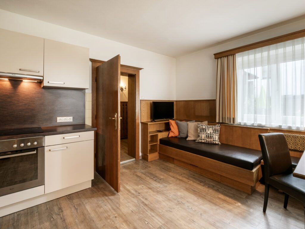 Moderne Küche mit Essecke in einer gut beleuchteten Wohnung.